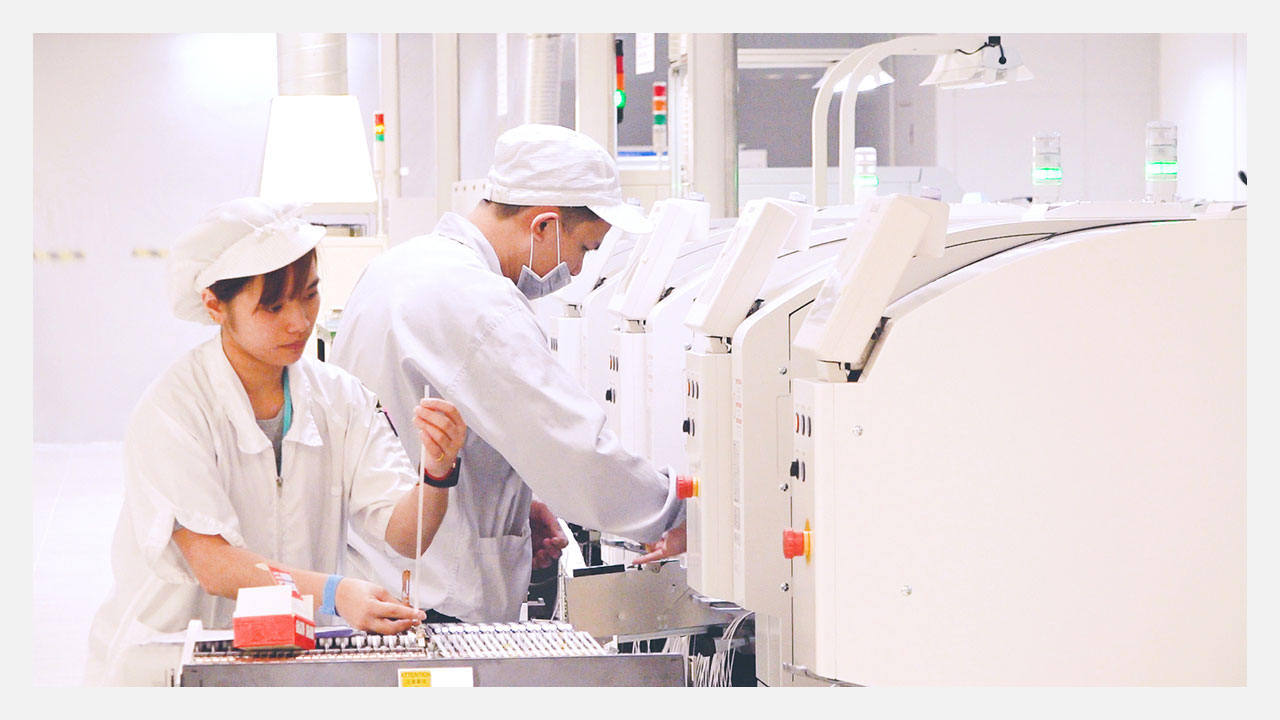 manufacturing services smt line two workers replacing components